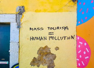 Graffiti: Mass Tourism = Human Pollution" (Photo by Mark de Jong on Unsplash)