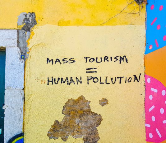 Graffiti: Mass Tourism = Human Pollution" (Photo by Mark de Jong on Unsplash)